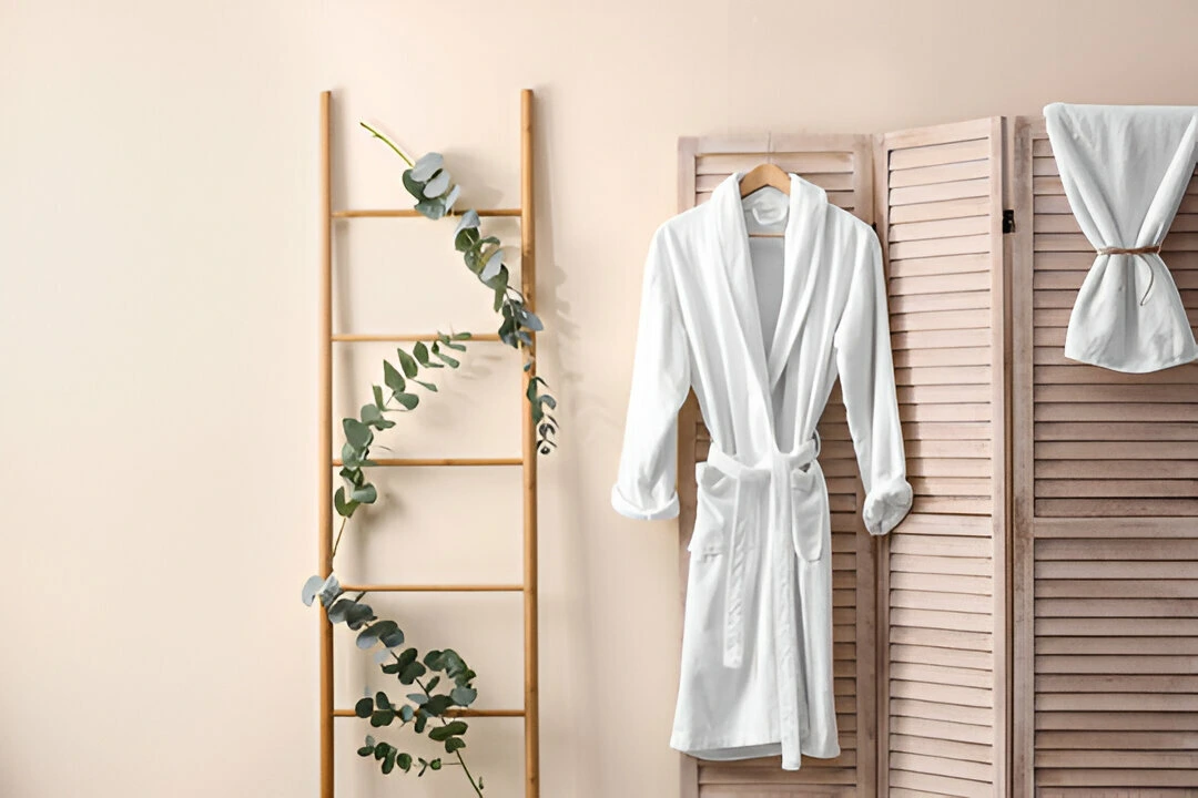 comfortable bathrobe hanging on folding screen